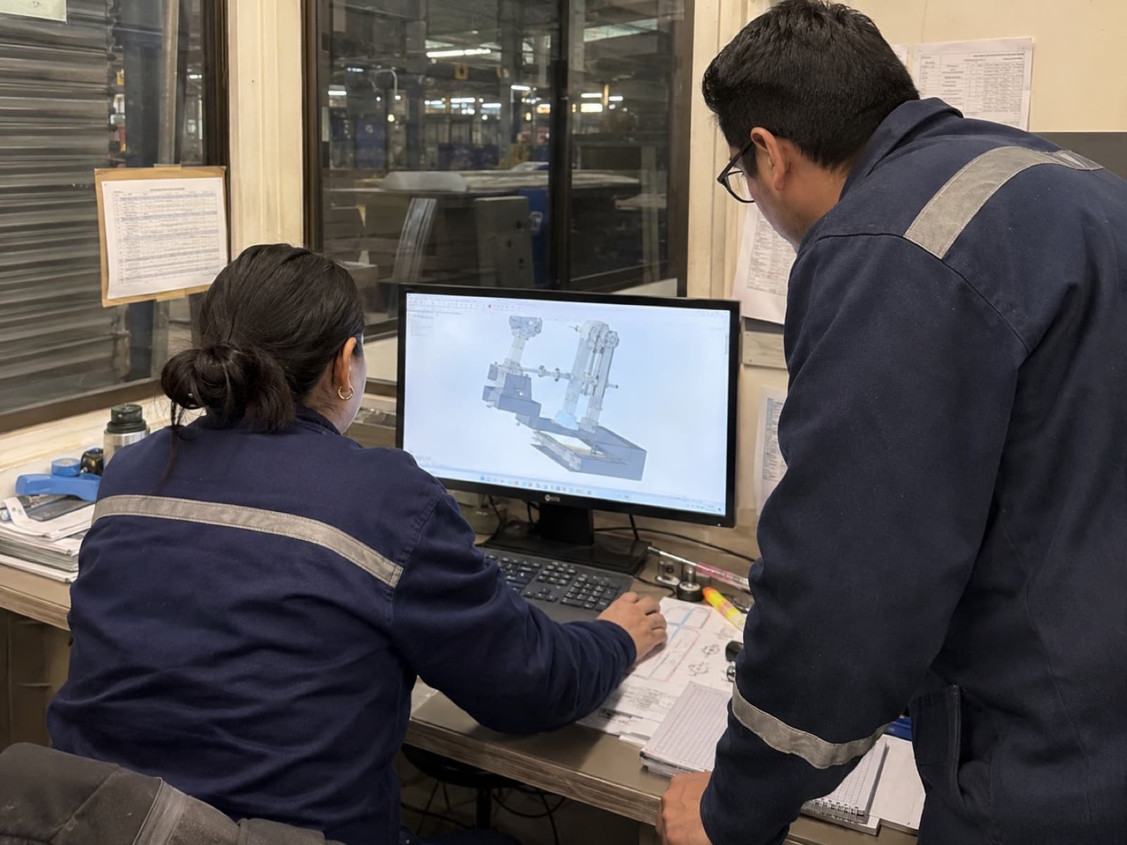 Two FractalWorks engineers reviewing a CAD assembly on screen